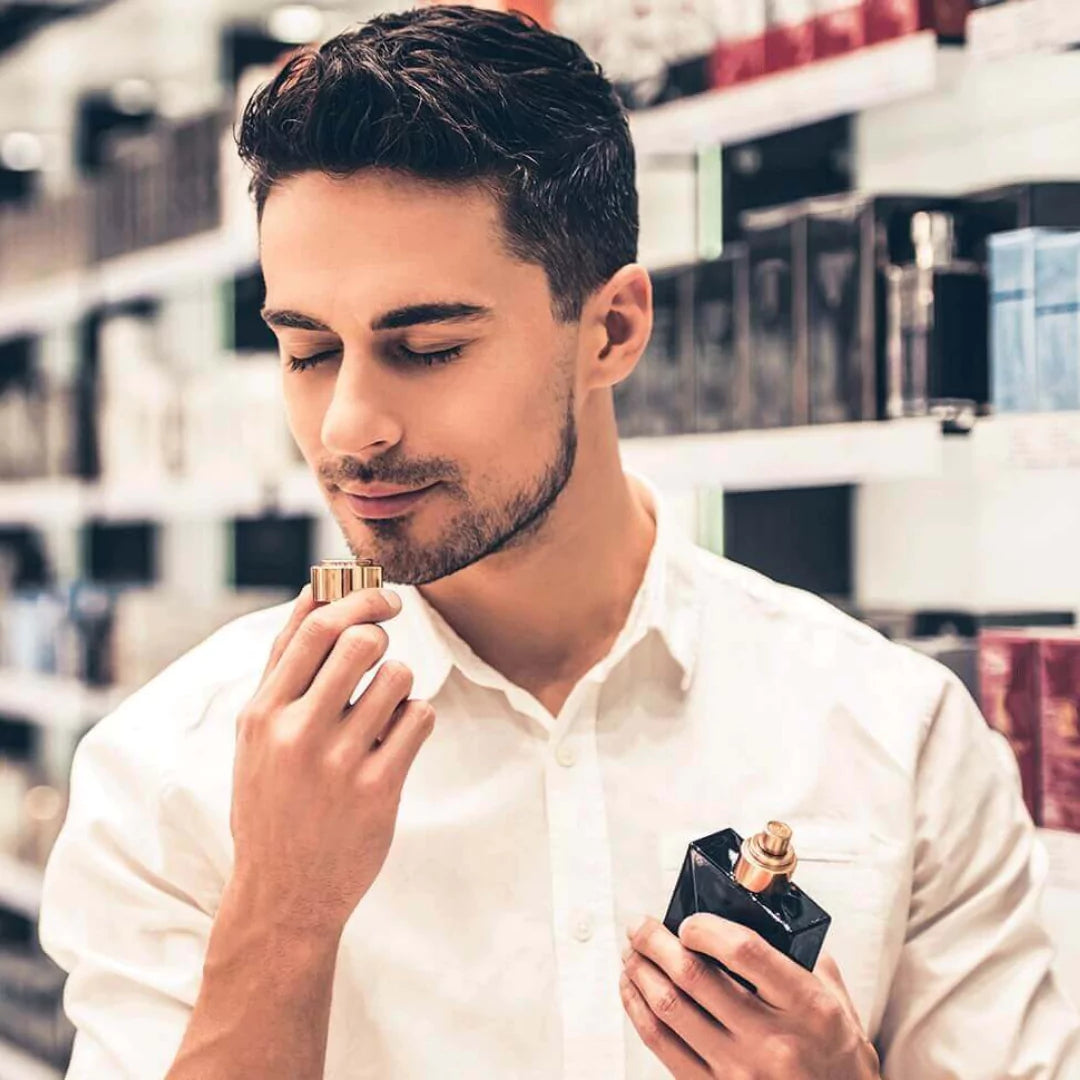 Man holding two perfume bottles in a store setting