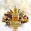 Gold bottle of oud wood perfume with spices and wood on a reflective surface